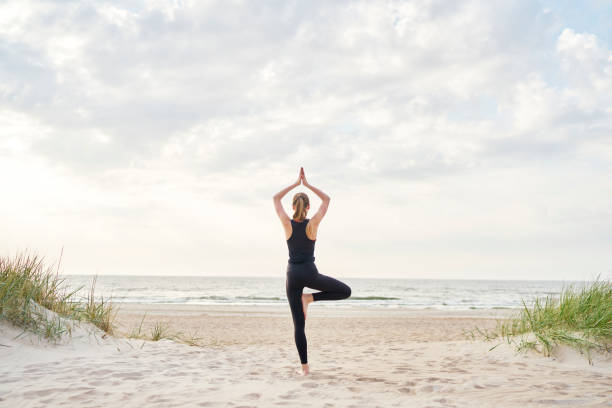 Woman Doing Yoga Poses On The Beach Photograph by Howard Snyder